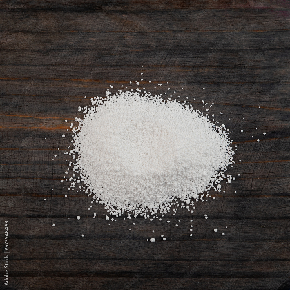 Pile of Sodium benzoate, sodium salt of benzoic acid on wooden surface, close-up. White crystalline powder, C6H5COONa. Food additive E211, Preservative Pile of Sodium benzoate, sodium salt of benzoic acid on wooden surface, close-up. White crystalline powder, C6H5COONa. Food additive E211, Preservative