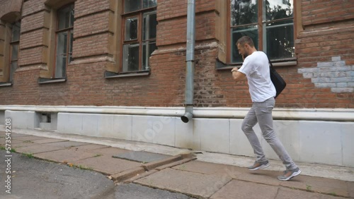 Wallpaper Mural Businessman running along urban street because late for work. Young man in casual wear with briefcase has business conversation by phone rushing to job or study. Concept of career. Slow motion Torontodigital.ca