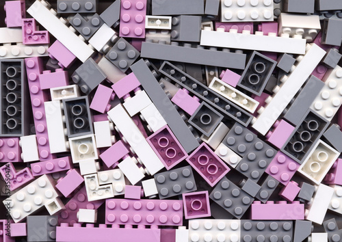 Lot of pink, gray and white blocks background. Many assorted building bricks of pastel colors. Educational toy for children