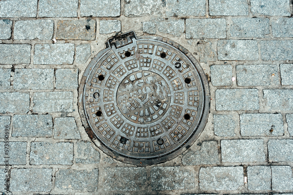 Cast-iron road hatch on stone road in Istanbul