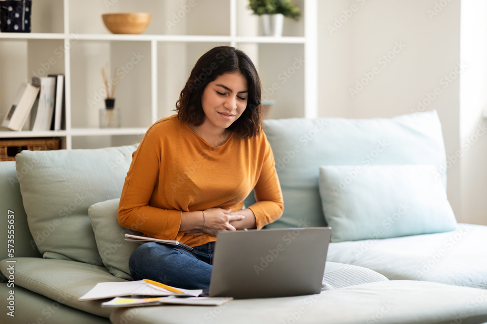 Sick Arab Woman Suffering Stomach Ache While Study With Laptop At Home Sick Arab Woman Suffering Stomach Ache While Study With Laptop At Home