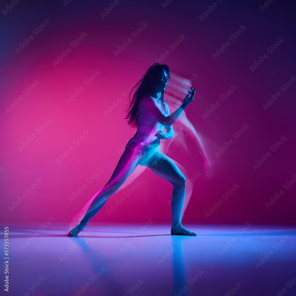 Feelings. Young woman dancing modern dance style over gradient pink studio background in neon with mixed lights. Concept of contemporary dance style, art, aesthetics, hobby, creative lifestyle