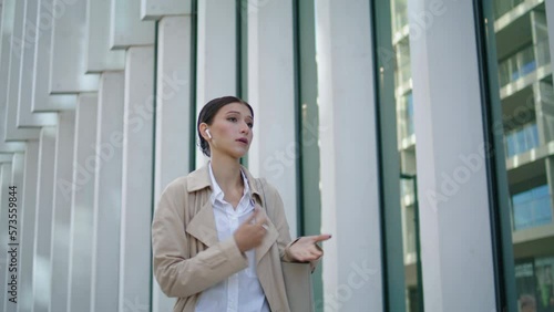 Wallpaper Mural Woman calling phone earbuds walking on city street closeup. Lady speaking mobile Torontodigital.ca