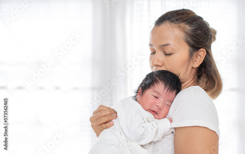 happy loving family. mother playing with her baby hugging in the bedroom , portrait of asian mother playing with newborn baby, health care family love together. asian girl lifestyle..