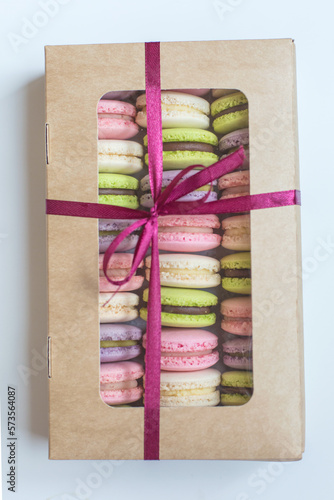 Macaroons in box. French macaroon cake. Sweet macarons or macaroons, flavored cookies are in the paper box on white background. Colorful pink blue yellow green macaron. Sweet macaroons macarons. photo