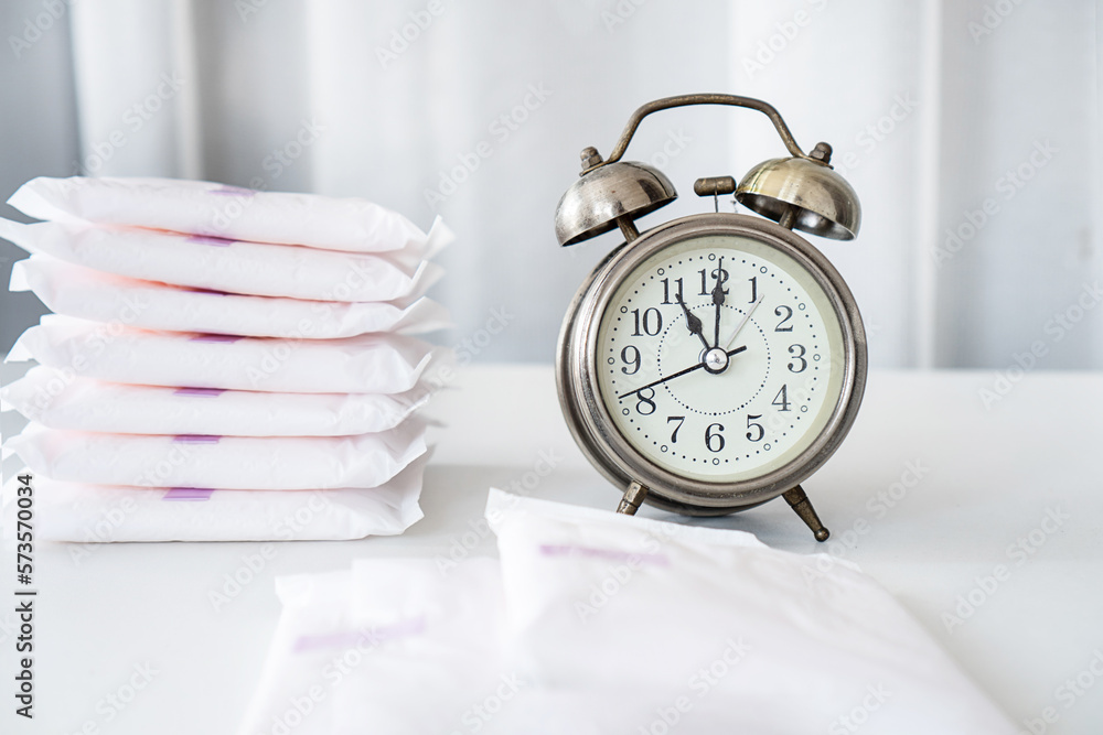 Stockfoto Changing Pads, don't wear a pad too long concept with an alarm clock and menstrual