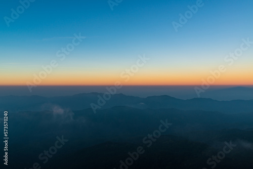 Panoramic twilight view while morning mist covered partly mountain seen from the highest peak of Doi Pha Hom Pok, Fang, Chiang Mai, Thailand.