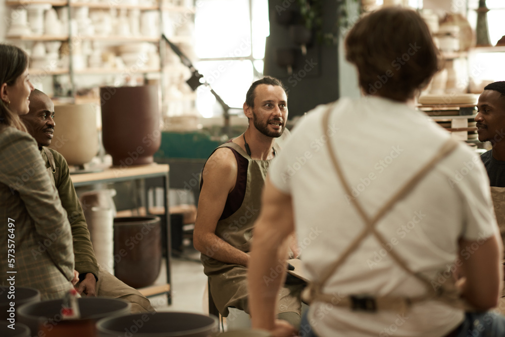Smiling ceramists having a meeting in a pottery studio Smiling ceramists having a meeting in a pottery studio