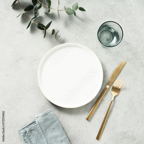 Minimal styled table setting with eucalyptus branches. Top view with copy space.