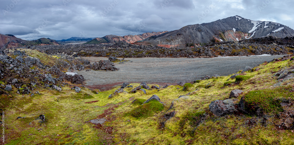 Panoramic Icelandic landscape of colorful rainbow volcanic Landmannalaugar mountains, at Laugavegur hiking trail with dramatic sky, colorful rhyolite volcano soil and lava fields in Iceland.
