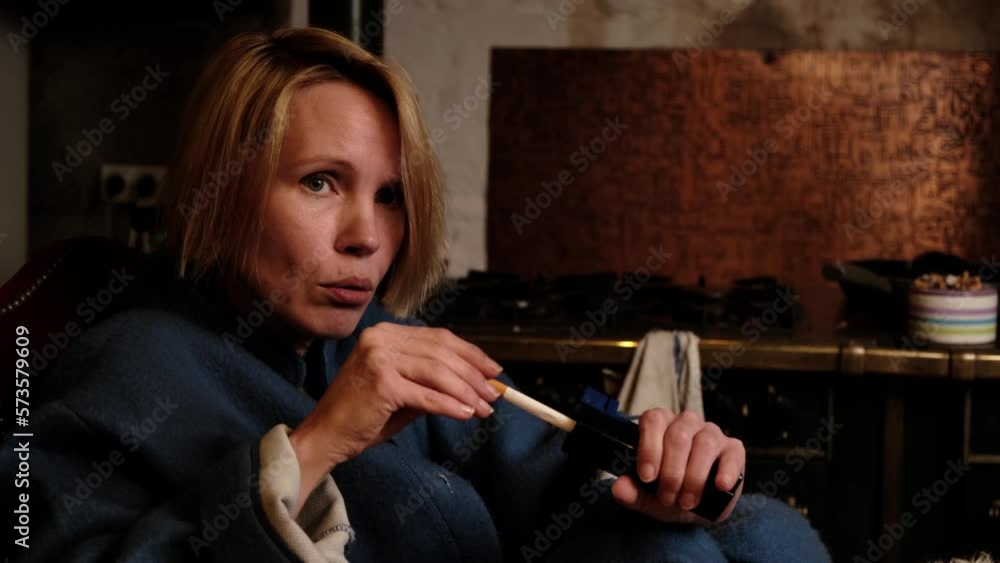 A woman makes her own cigarette. A device for manually stuffing tobacco into a cigarette sleeve in a woman's hands. A woman makes her own cigarette. A device for manually stuffing tobacco into a cigarette sleeve in a woman's hands.