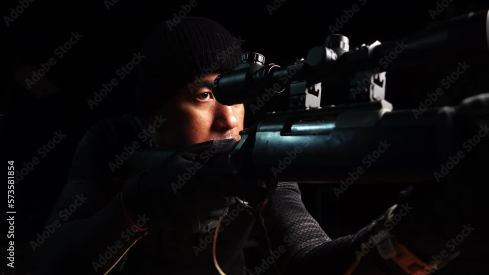 A police with a sniper rifle aims at the lens and prepares to shoot A police with a sniper rifle aims at the lens and prepares to shoot
