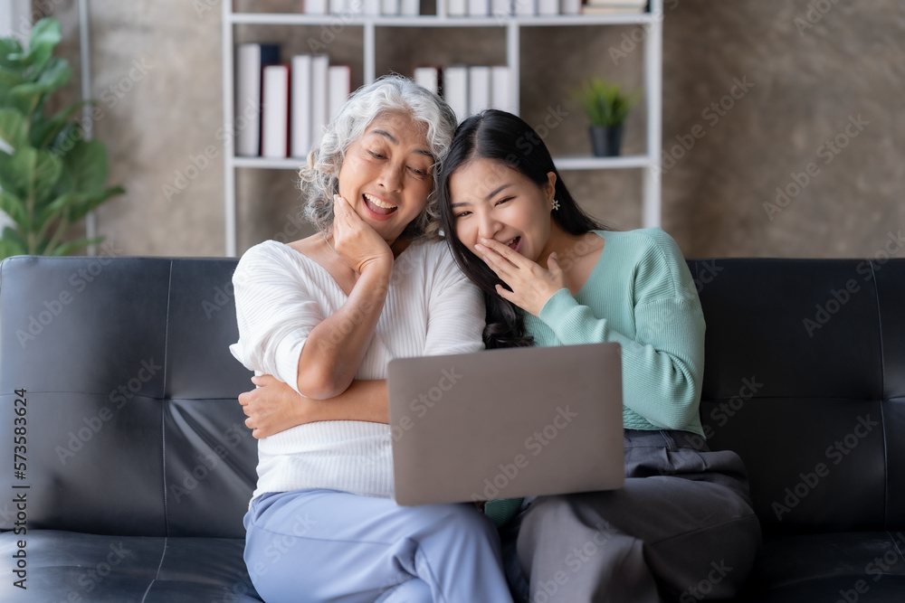 Asian mother and daughter using laptop for video call at home on vacation. Asian mother and daughter using laptop for video call at home on vacation.