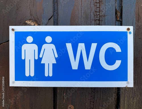 Sign for public toilet with one male and one female picture and the letters WC