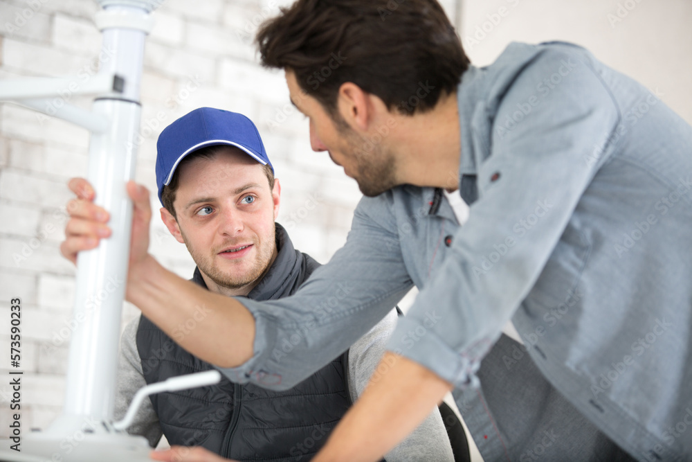 Obraz premium worker with apprentice repairing a chair