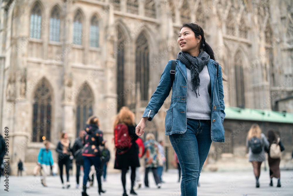 carefree Asian woman enjoy sight seeing travel in front of famous church in Vienna tour in downtown. Young woman exploring famous old architecture Stephansdom cathedral church in downtown