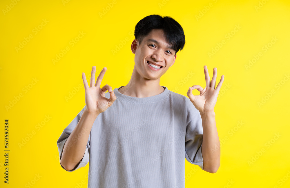 image of handsome young man posing on a yellow background image of handsome young man posing on a yellow background