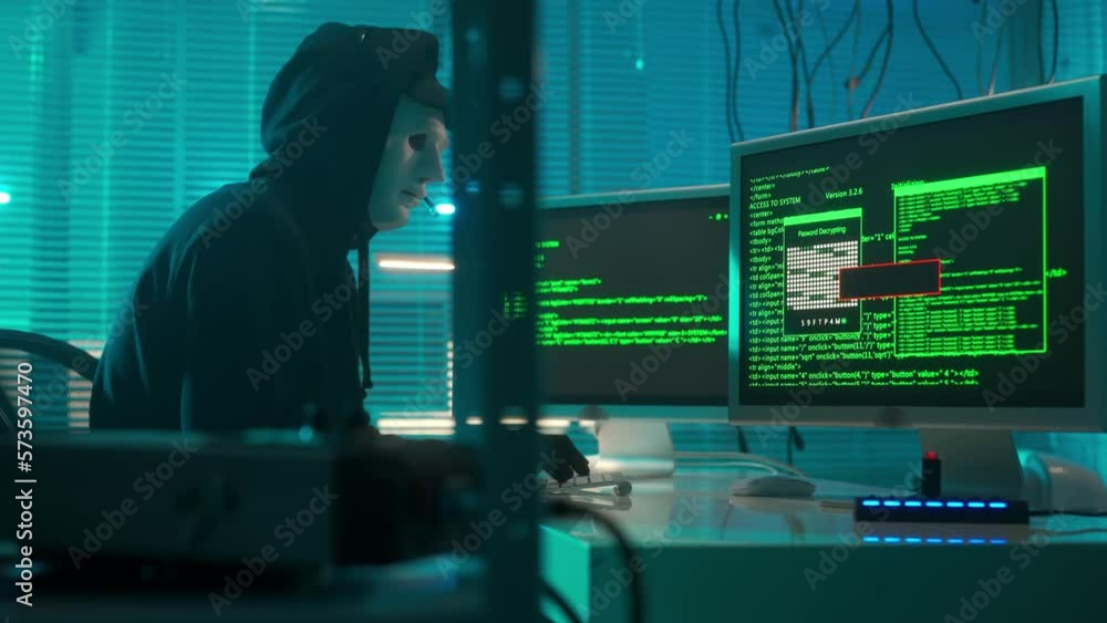 Hacker in a white mask is typing on a computer keyboard and cracking a ...