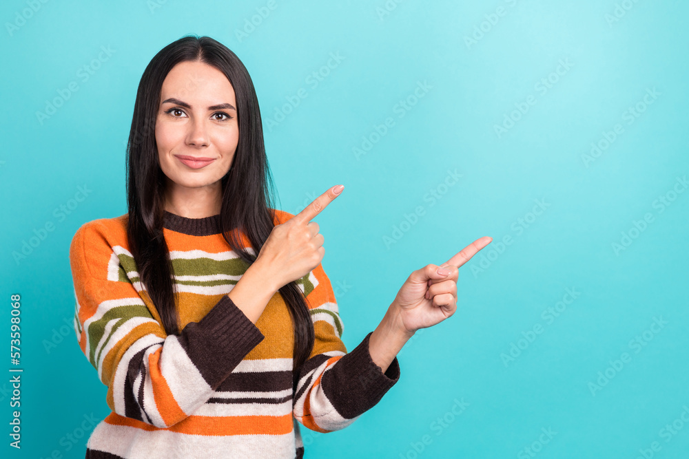 Photo of serious confident promoter adorable pretty woman indicates demonstrate fingers mockup product isolated on aquamarine color background Photo of serious confident promoter adorable pretty woman indicates demonstrate fingers mockup product isolated on aquamarine color background