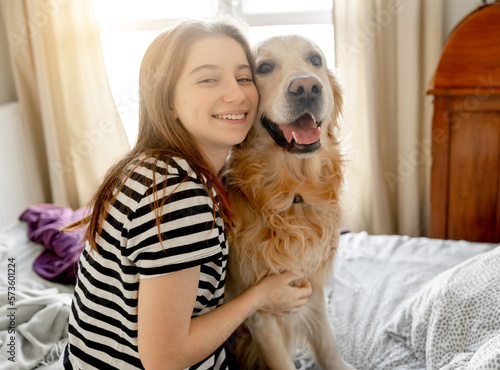 Girl with golden retriever dog in bed
