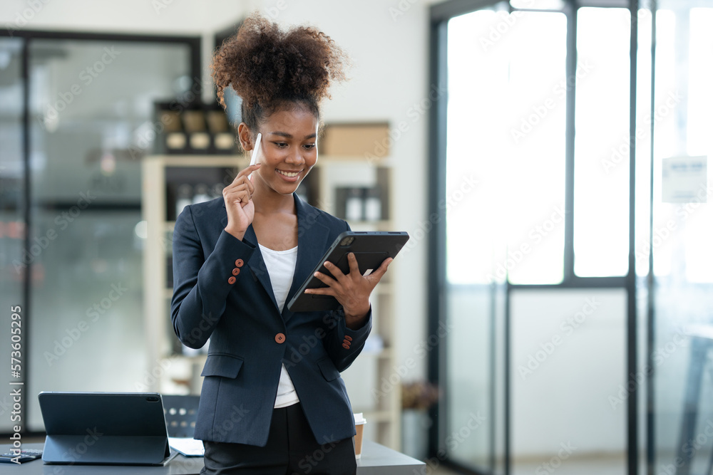 Smiling african american businesswoman holding tablet standing happy working in the financial field Banking in the office in the office business woman manager concept. Smiling african american businesswoman holding tablet standing happy working in the financial field Banking in the office in the office business woman manager concept.