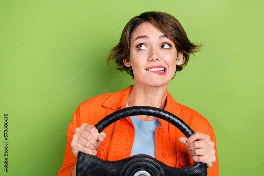 Photo of sweet unsure woman wear denim jacket biting lip riding car looking empty space isolated green color background Photo of sweet unsure woman wear denim jacket biting lip riding car looking empty space isolated green color background