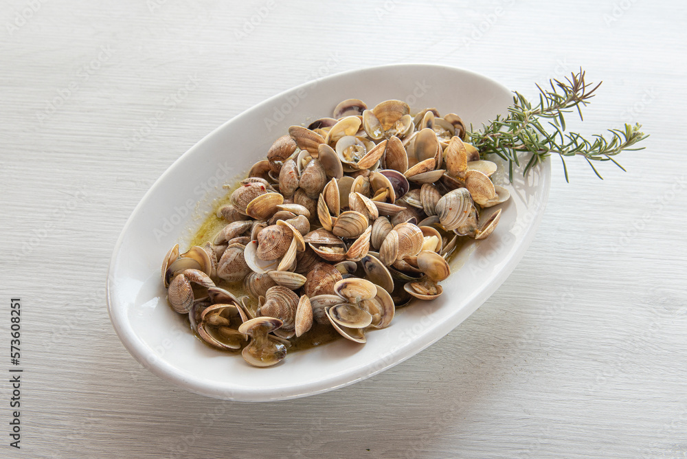 plate of cooked sea clams seasoned with rosemary, photo from the other close a on white rustic wood background , orizontal plate of cooked sea clams seasoned with rosemary, photo from the other close a on white rustic wood background , orizontal