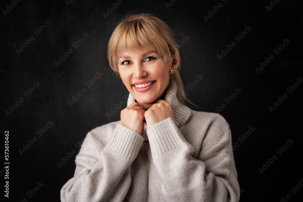 Studio portrait of an attractive middle age woman against dark background Studio portrait of an attractive middle age woman against dark background