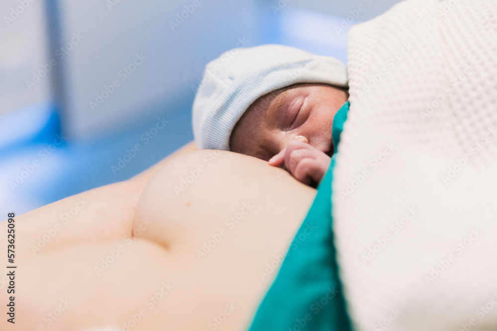 Newborn baby sleeping on his mother's chest after birth in hospital