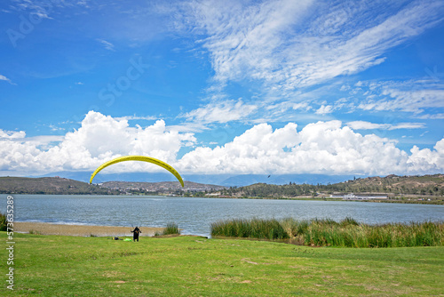 Beautiful view of the Yahuarcocha lake with a paraglider after his flight. Yahuarcocha, Imbabura province, Ecuador. photo