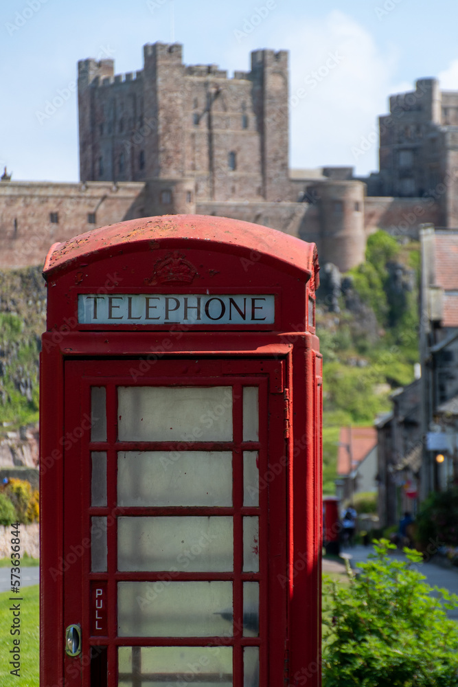 Close up of a traditional red UK telephone box in Bamburgh, UK. Castle out of focus Close up of a traditional red UK telephone box in Bamburgh, UK. Castle out of focus