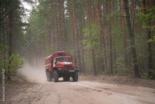 Fire truck on dusty road in pine forest