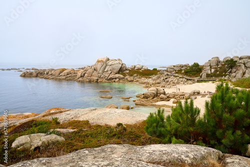 Galician beach with rocks and blue sky. Nature background.