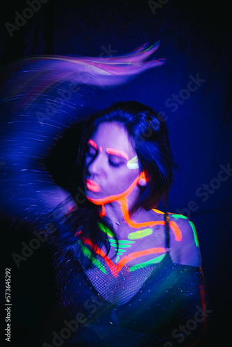 Model woman in neon light, beautiful model girl with fluorescent makeup, art design of disco dancer dancing in uv light, colorful makeup. Nightclub, Party. 4K video.