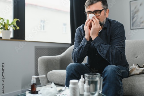 Man wrapped in plaid on the sofa feeling sick illness at home