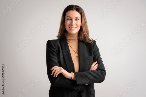 Confident mid aged woman wearing black blazer and standing at isolated background photo