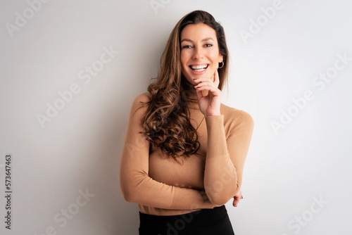 Attractive middle aged businesswoman standing with arms crossed against isolated background