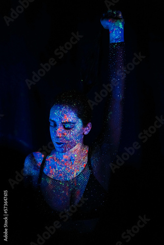 A beautiful young girl with makeup from ultraviolet paints smokes. Releases smoke from the mouth. Holiday of colors holly. Bright, colorful, festive coloring book. Fluorescent makeup on the face. © Yuliia