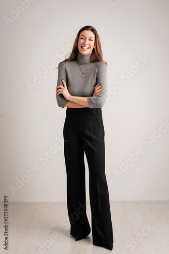 Full length studio portrait of attractive brunette haired woman posing at isolated background