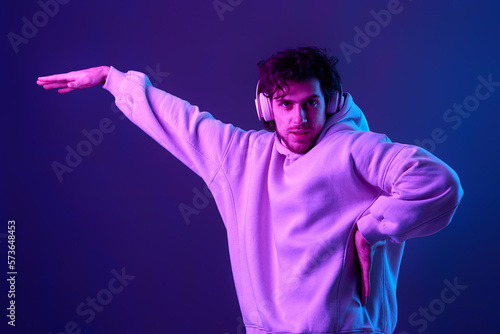 man with headphones in sweatshirt enjoying favorite tracks