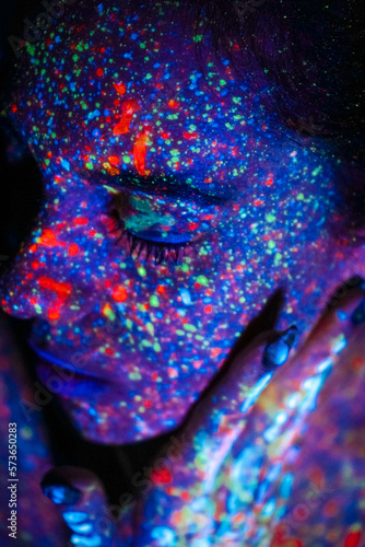 Portrait of a beautiful woman with blue sequins on her face. Girl with artistic make-up in Light color. Fashion model with colorful makeup.
