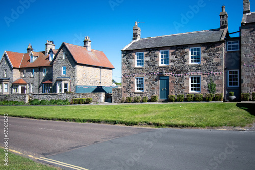 Bamburgh village green and cottages. Decorated with bunting during Platinum Jubilee celebrations, June 2022. Northumberland, UK