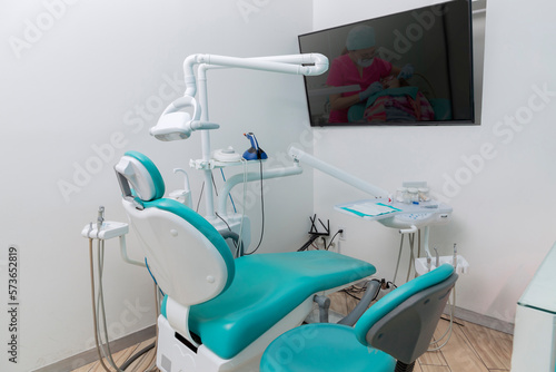 Dental office with work equipment and a screen on the wall