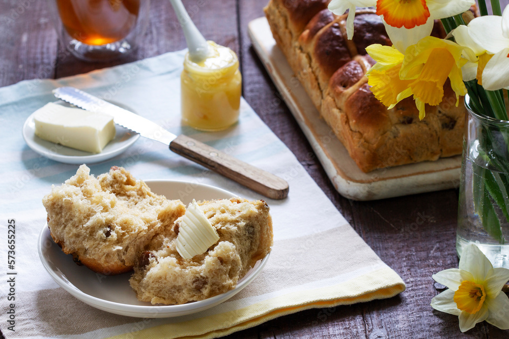 Cross buns served with butter, honey and tea. Easter breakfast.