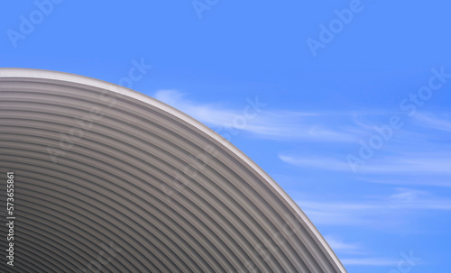 Curve pattern of Large Corrugated Steel Roof against blue sky background, low angle view with copy space