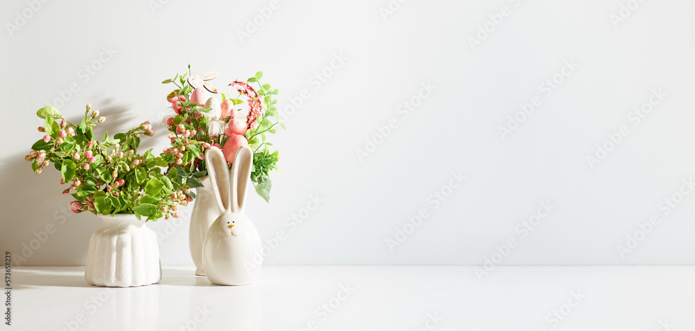 Spring flowers in a vase and easter bunny on a light background. Easter background with copy space