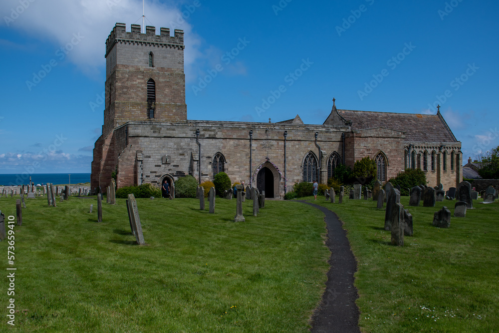 The exterior of St Aidan's Church and churchyard in Bamburgh, Northumberland, UK