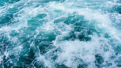 White splash foams behind a ship engine on the sea. Foam bubbles on sea water surface . © Akin Ozcan