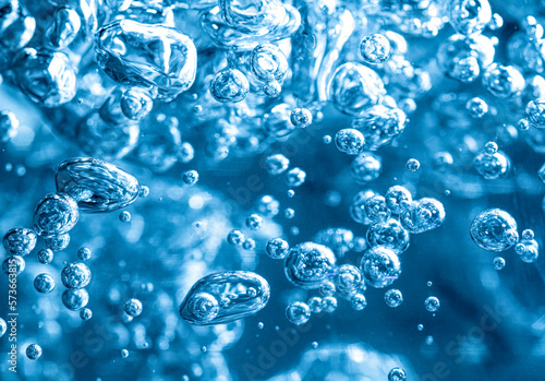 Close up of transparent air bubbles in water in blue tone.
