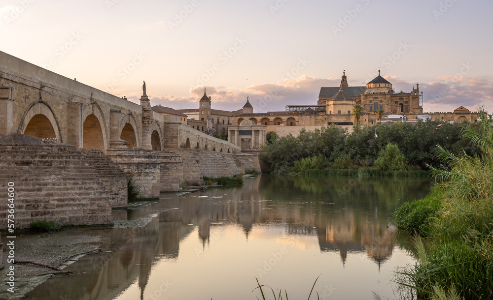 Exposure at sunset of the Roman bridge of and the Mosque–Cathedral of Cordoba in the background with the Guadalquivir river in the foreground